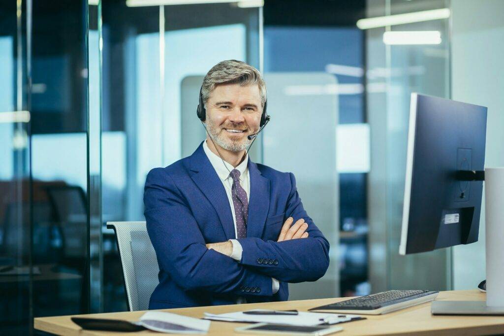 Portrait of senior and experienced businessman with headset for video communication